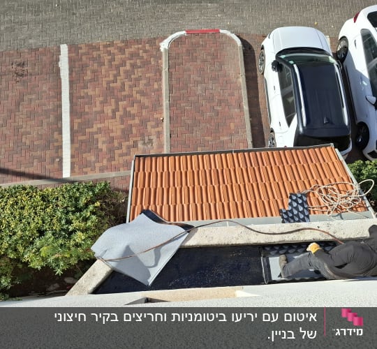 אדם מבצע איטום גג עם יריעות ביטומניות